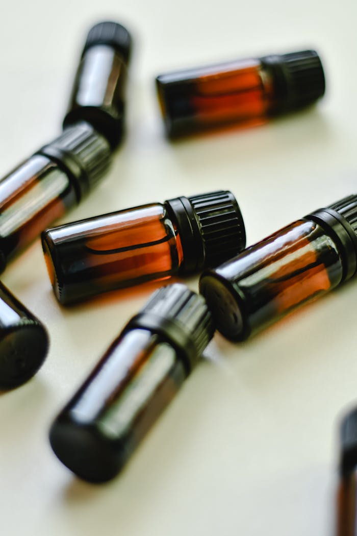Collection of small amber glass bottles with black caps on a white background for product display.